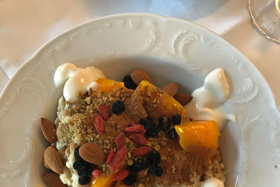Frühstück à la Monica Meier-Ivancan: Getreidebrei mit gedünsteter Mango, getrockneten Goji und Aronia Beeren, Kokosjoghurt, Wurzelkraftpulver und Mandeln