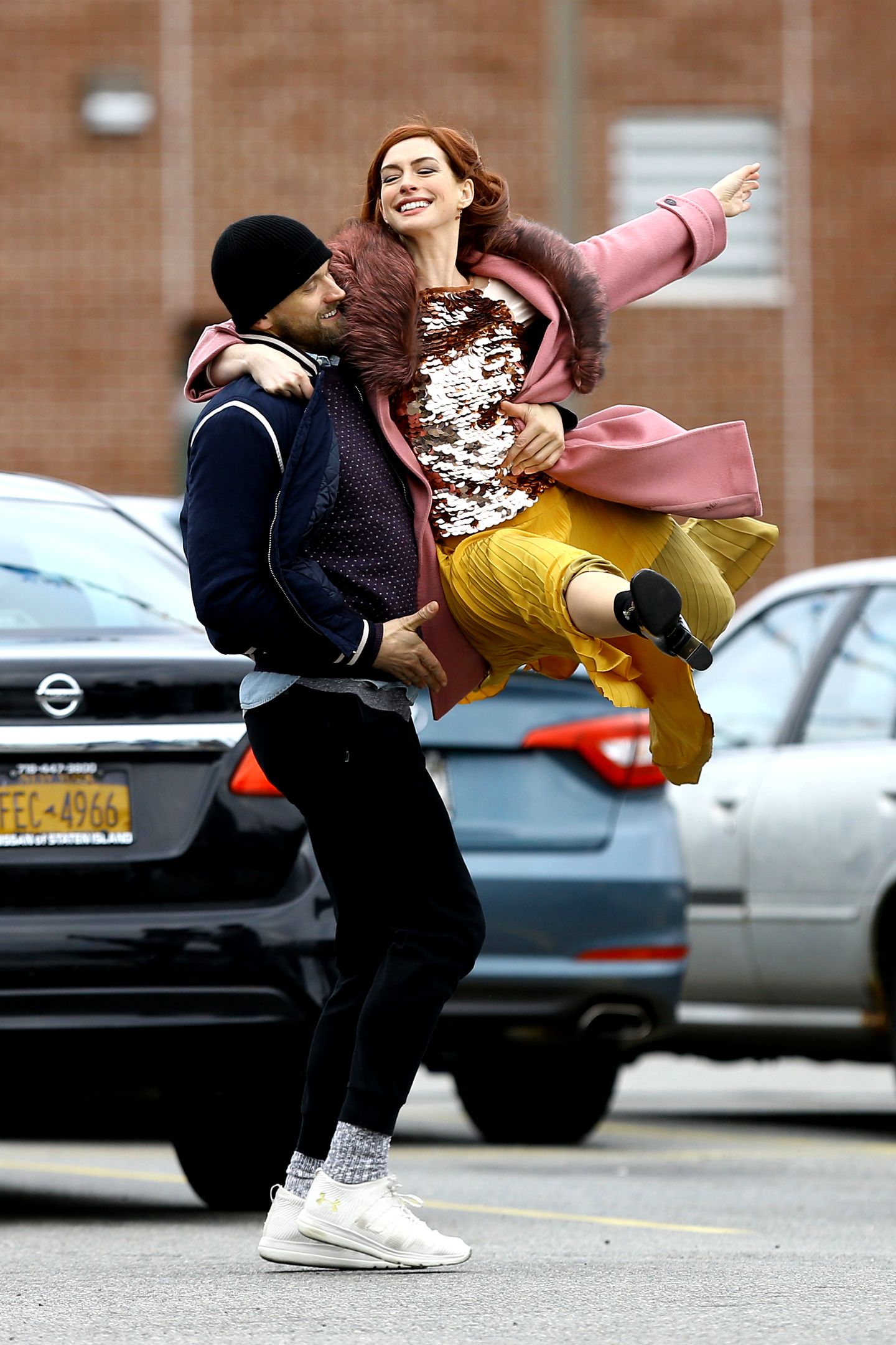 Eine rothaarige Anne Hathaway tanzt ausgelassen auf einem Parkplatz in Brooklyn. Der oscarprämierte Superstar gehört zum Cast der kommenden Amazon-Serie "Modern Love".