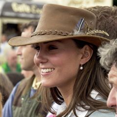 August 2005  Als Freundin des jungen Prinzen stand Kate schon früh im Fokus der Aufmerksamkeit. Zu einem hellbraunen Hut mit lässigem Hutband und Federdetails trägt sie schicke Perlenohrringe. Das fröhliche Lächeln ist bis heute eins ihrer Markenzeichen. 