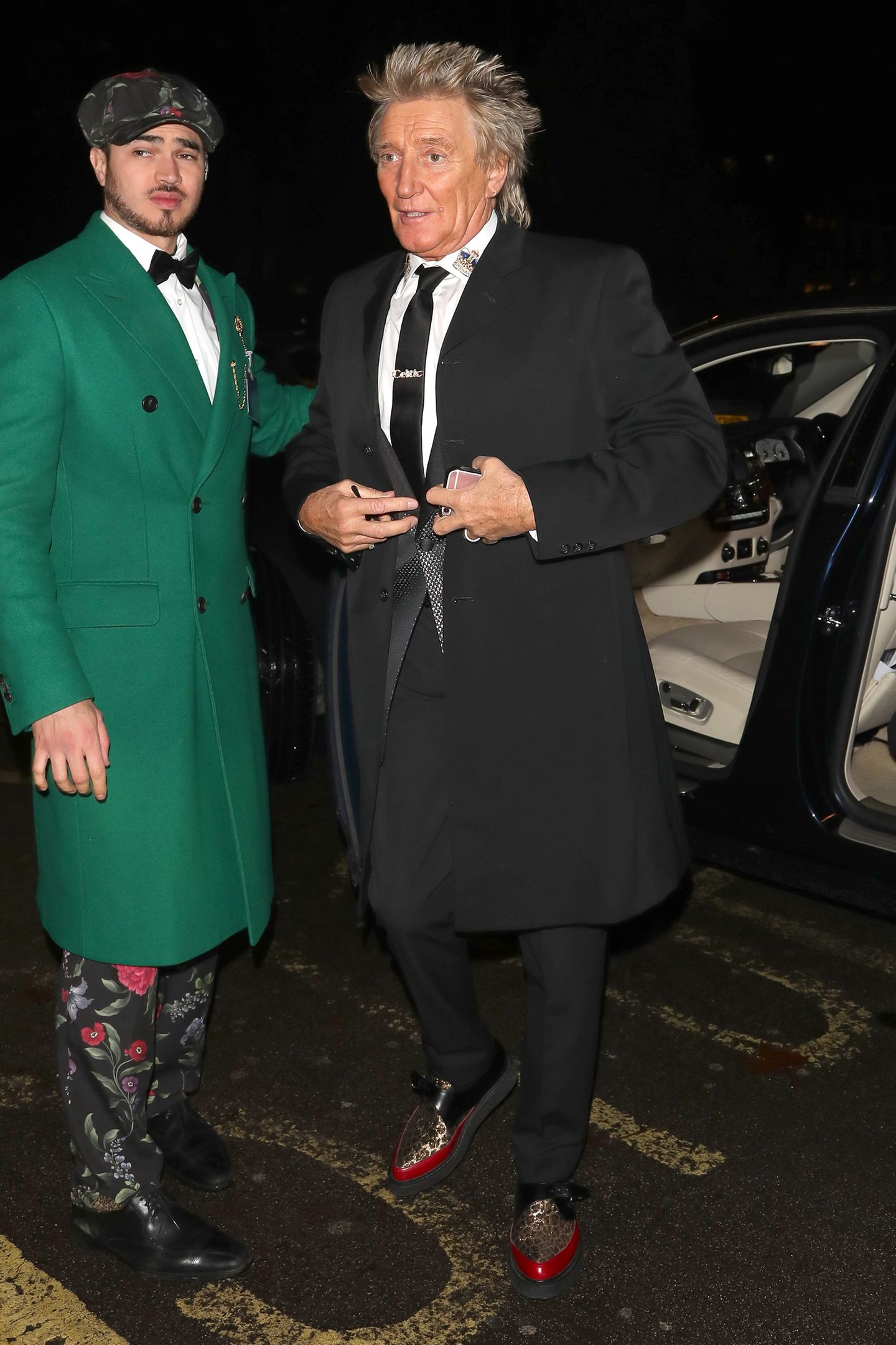 Bei seiner Ankunft auf einer Londoner Weihnachtsparty bekommt Sänger Rod Stewart von einer ganz besonderen Gestalt die Autotür aufgehalten. Ein grüner Weihnachtsgrinch? Nein, wohl eher ein extrem modischer Helfer der Stars. Dieser junge Mann raubt jedem Promi bei der Ankunft die Show!