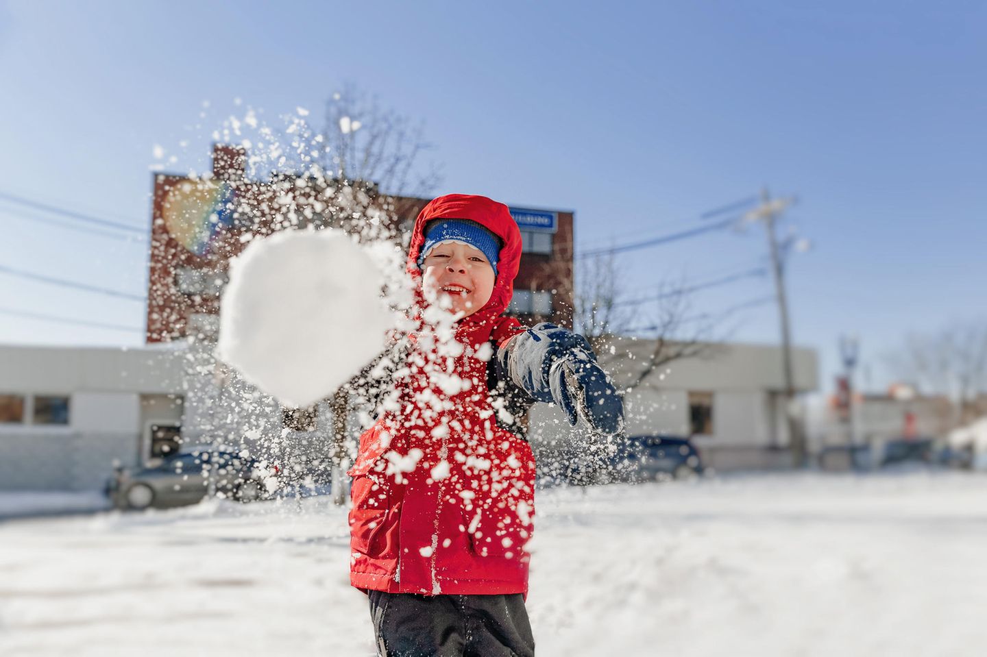 Volle Kraft voraus: Ein Junge setzt zur Schneeballschlacht an
