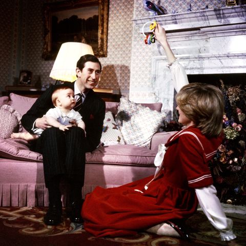 1982  Der kleine Prinz William sitzt auf dem Schoß seines Vaters Prinz Charles und schaut fasziniert auf das Spielzeug, das seine Mutter Prinzessin Diana hochhält.