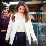 Königin Rania liebt Outfits mit dem gewissen Etwas: Beim Besuch des Dorfes Wadi Al Naqa kombiniert sie zu einem weißen Rollkragen-Pullover eine ebenfalls weiße Jacke und eine Hose, die mit raffinierten Knöpfe und einem langen Reißverschluss besticht. 