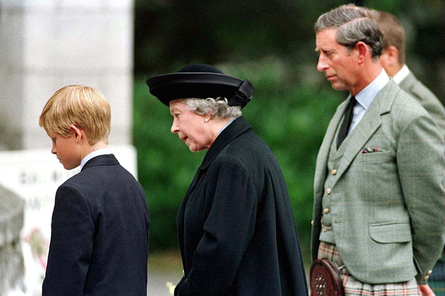 Prinz Harry (l.), Queen Elizabeth (M.) und Prinz Charles (r.) betrachten am 4. September1997 vor den Toren von Schloss Balmoral die Blumenspenden, die für Prinzessin Diana niedergelegt wurden