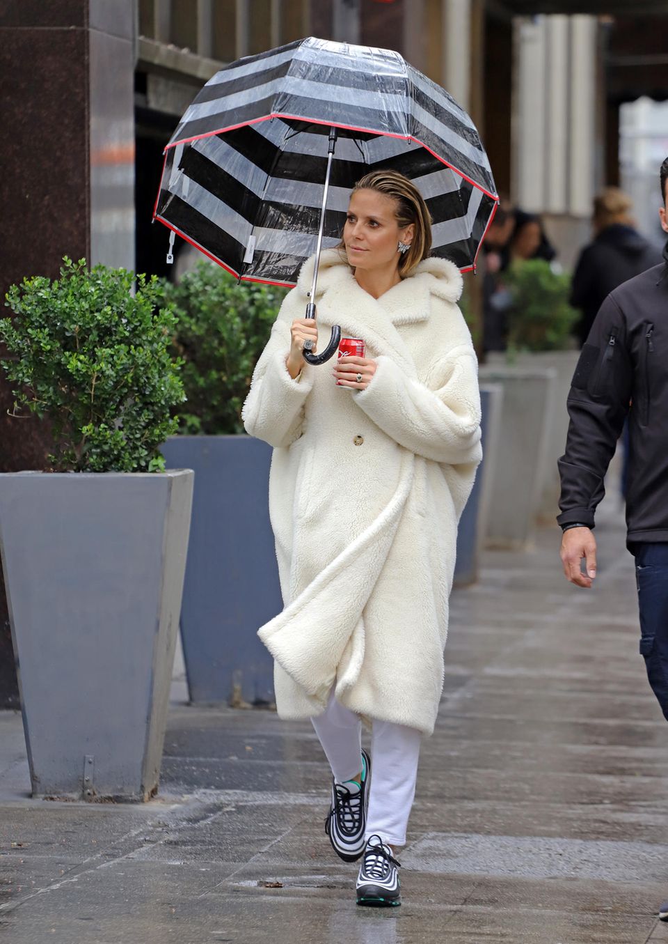 Babygerücht um Heidi Klum : Ebenfalls am Valentinstag wird Heidi in einer Drehpause von "GNTM" in einem kuscheligen, weißen Teddy Coat fotografiert. An ihrer Hand funkelt ihr Verlobungsring von Tom Kaulitz. Auch hier ist der Bauch wieder versteckt Am gleichen Tag wird sie in einem kuscheligen, weißen Teddy Coat fotografiert. Was aussieht, wie eine Coca-Cola-Werbung, ist während der Drehpausen der 14. Staffel von "Germany's next Topmodel" entstanden. Haare und Make-up sitzen, der Verlobungsring an ihrer Hand funkelt mit den auffälligen Schmetterlingsohrringen um die Wette.