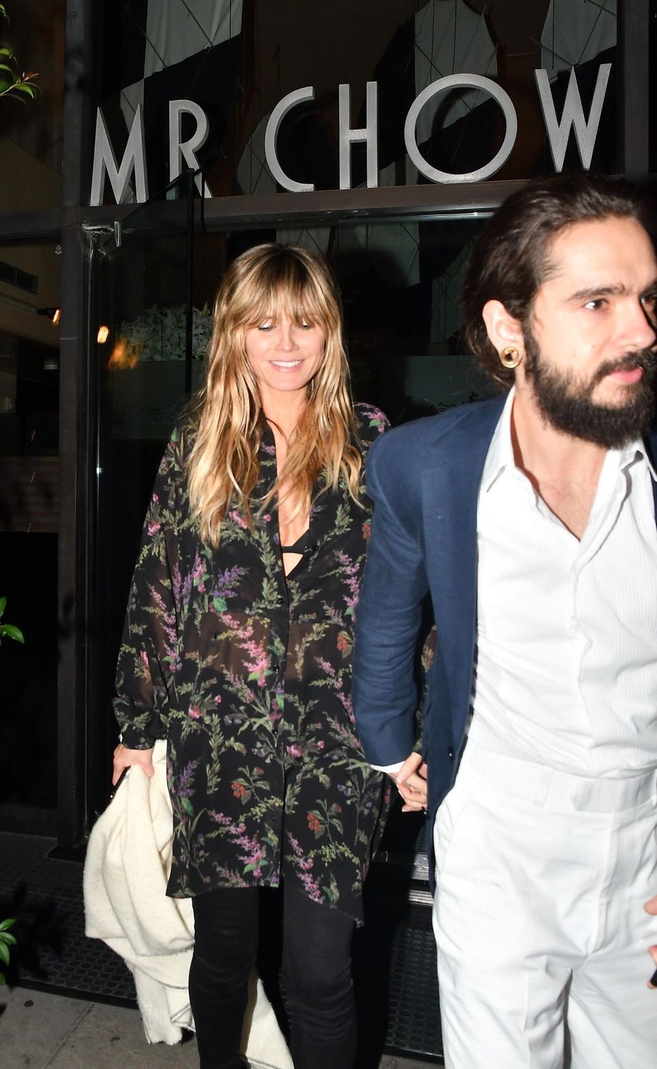 Heidi Klum: Hand in Hand verlassen Heidi Klum und Tom Kaulitz im Februar ein Restaurant. Warum so schüchtern, Heidi? Paparazzi erwischen Heidi Klum und Tom Kaulitz beim Verlassen des Nobel-Chinesen Mr. Chow in Beverly Hills. Während Tom für die Date-Night eine weiße Anzughose samt weißem Hemd und einem blauen, taillierten Blazer trägt, kaschiert seine Liebste ihre Körpermitte mit einer schwarzen Tunika samt floralem Muster. Doch so ganz blickdicht ist die Bluse nicht ...