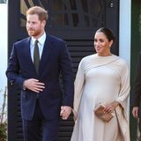 Am Abend wird es noch glamouröser: Harry und Meghan zeigen sich beim Besuch der britischen Botschaft in Abendgarderobe. Während der Prinz einen dunkelblauen Anzug wählt, zeigt sich Meghan in einem cremefarbenen Abendkleid von Dior. Das Dress ist - wie ihr Kleid am Tag zuvor - mit einem Cape ausgestattet. Zu dem aufregenden Kleid kombiniert Meghan eine goldene Clutch sowie gleichfarbige Pumps, beides ebenfalls von Dior. 