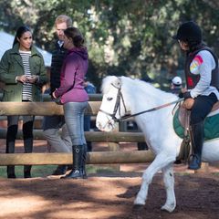 Beim Rundgang über den Hof werden die Royals Zeuge einer Reitstunde: Ein junges Mädchen lernt auf einem weißen Pony das Reiten. Harry und Meghan holen derweil von einer Mitarbeiterin des Hofes weitere Informationen ein. 