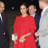 Herzogin Meghan trägt bei ihrer Ankunft in Marokko ein speziell für sie angefertigtes Capekleid von Valentino. Der elegante, sehr zurückhaltende Entwurf mit Stickerei zieht einzig durch das für den Designer so typische Signalrot die Blicke auf sich.