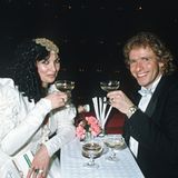 Für ihren Besuch beim Wiener Opernball im Jahr 1986 werfen sich die Gottschalks in Schale. Während Thea auf ein weißes Kleid mit aufwendig gerüschten Ärmeln und goldenem Kopfschmuck setzt, trägt Thomas einen schwarzen Smoking mit weißer Fliege. 