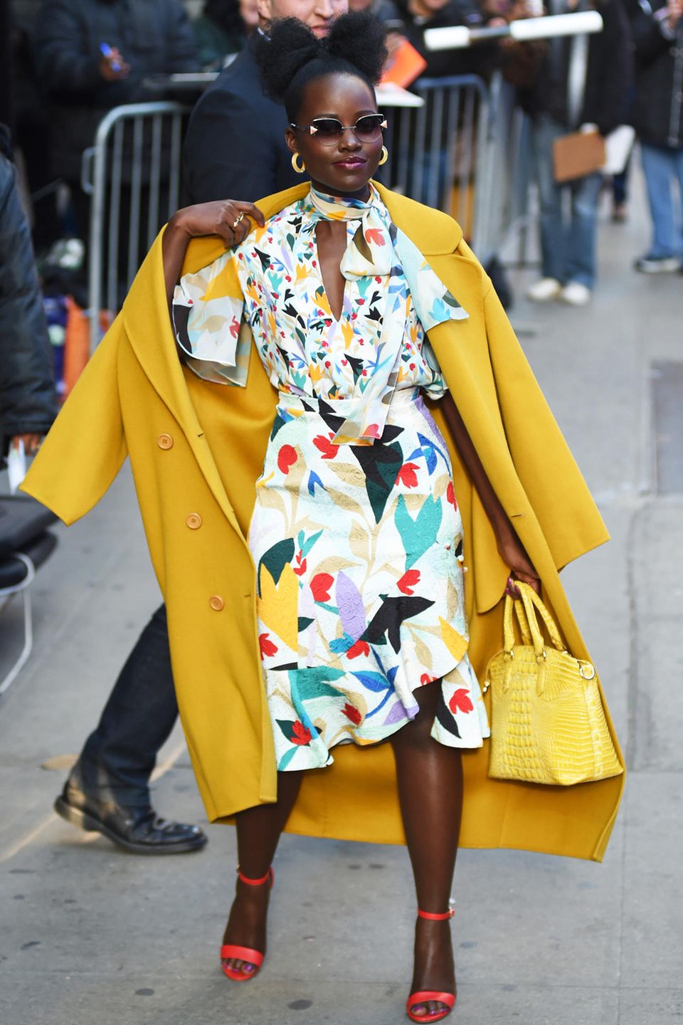 Hier kommt der Frühling! Lupita Nyong'o zeigt sich vor dem "Good Morning America"-Studio am New Yorker Times Square in einem floralen Look von Prabal Gurung, den sie mit einem sonnig gelben Mantel kombiniert.