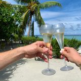 Unter blauen Himmel und Palmen lässt das Ehepaar die Champagner-Gläser klirren. Wo genau sie urlauben, verraten die Turteltauben allerdings nicht. 