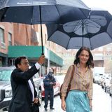 Damit Schauspielerin Katie Holmes trockenen Fußes am Ziel ankommt, wird sie gleich von zwei Schirmträgern begleitet. 