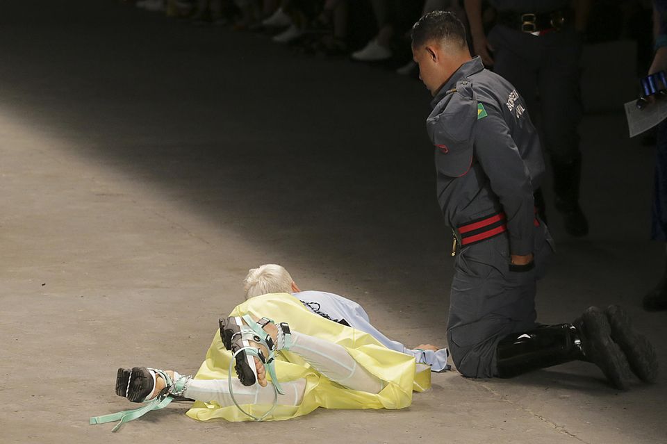 Model Tales Soares stirbt auf dem Catwalk : Tales Soares liegt auf dem Laufsteg, ein Sanitäter kniet neben ihm Tales Soares liegt auf dem Laufsteg, ein Sanitäter kniet neben ihm