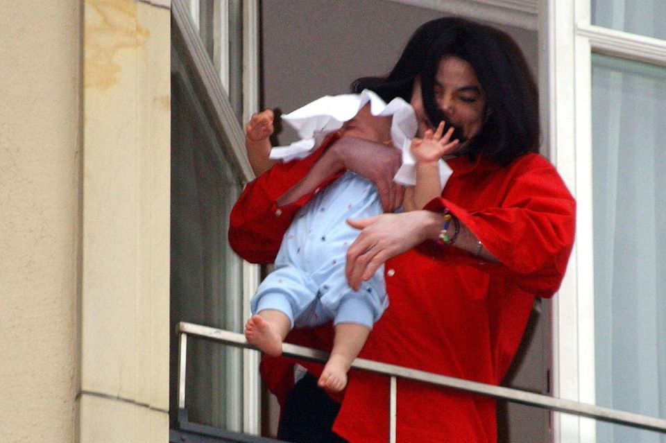 2002 hält Michael Jackson Baby Blanket aus dem Fenster eines Berliner Hotels.