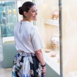Victorias elegantes, locker sitzendes Shirt besticht mit einem langen Reißverschluss am Rücken, ihre Ohren schmücken zarte Creolen. 