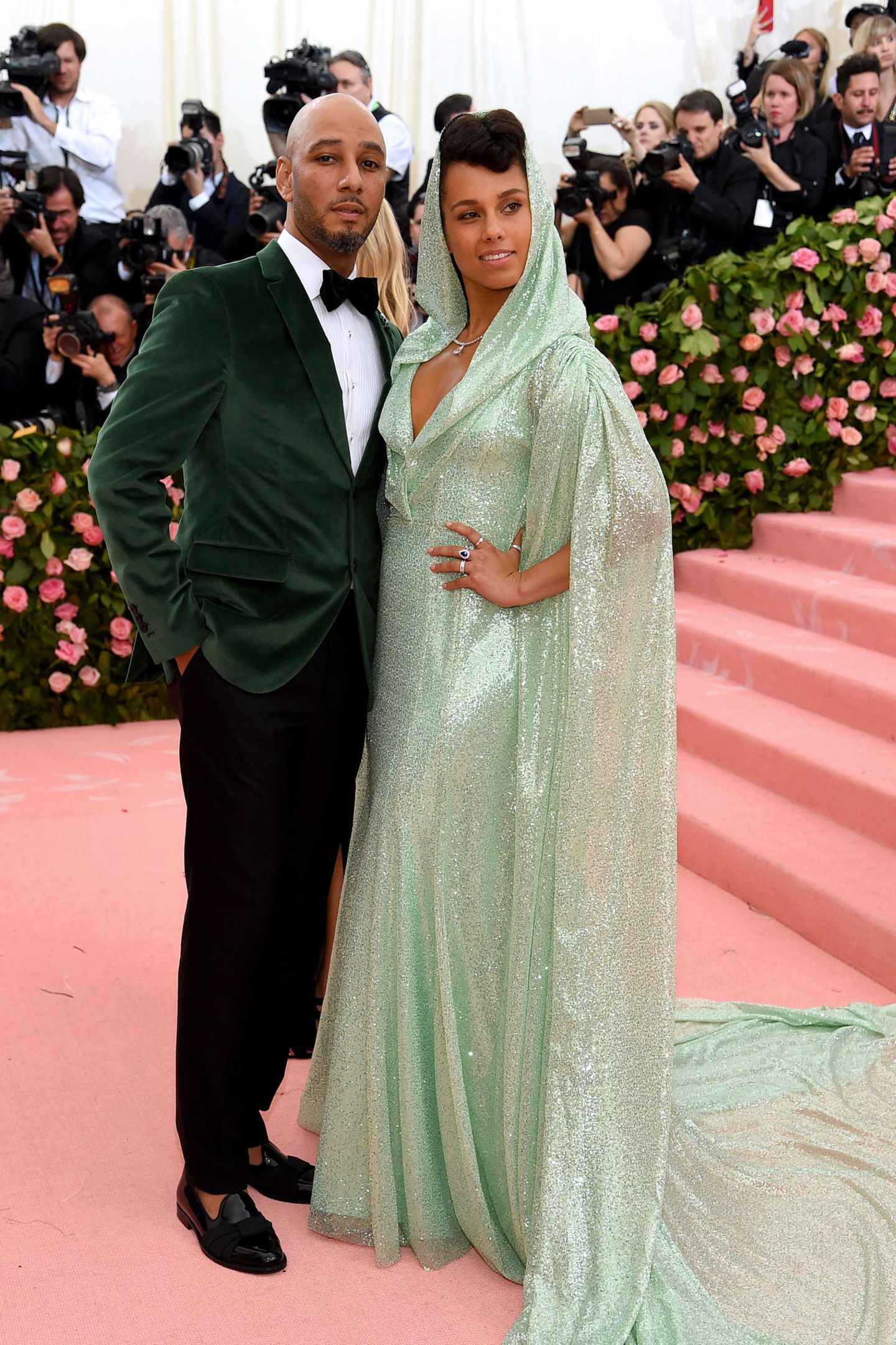 Auch Swizz Beatz und Alicia Keys haben ihre Looks farblich aufeinander abgestimmt: Während er auf ein waldgrünes Samt-Sakko setzt, trägt sie eine mintgrüne Robe mit Kaputze und langem Schleier. 