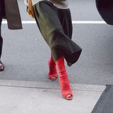 Zu ihrem Midi-Rock kombiniert Beckham echte Hingucker-Treter. Die knallroten High Heels legen die Zehen der Designer frei und dominieren das Outfit komplett. Victoria weiß eben, wie sie Aufmerksamkeit bekommt. 