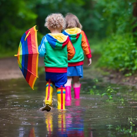 Kinder spielen in einer Pfütze