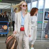 Elle Fanning zieht in einem beigen Anzug alle Blicke auf sich. Luxus-Accessoires von Chanel und Louis Vuitton runden ihren schicken Look ab. 