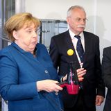 Hier ist Konzentration angesagt: Bundeskanzlerin Angela Merkel, NRW-Ministerpräsident Armin Laschet (links) und der Gründer der Junior Universität in Wuppertal Ernst-Andreas Ziegler (mitte) versuchen, einen Tischtennisball auf einem Föhn zu jonglieren.