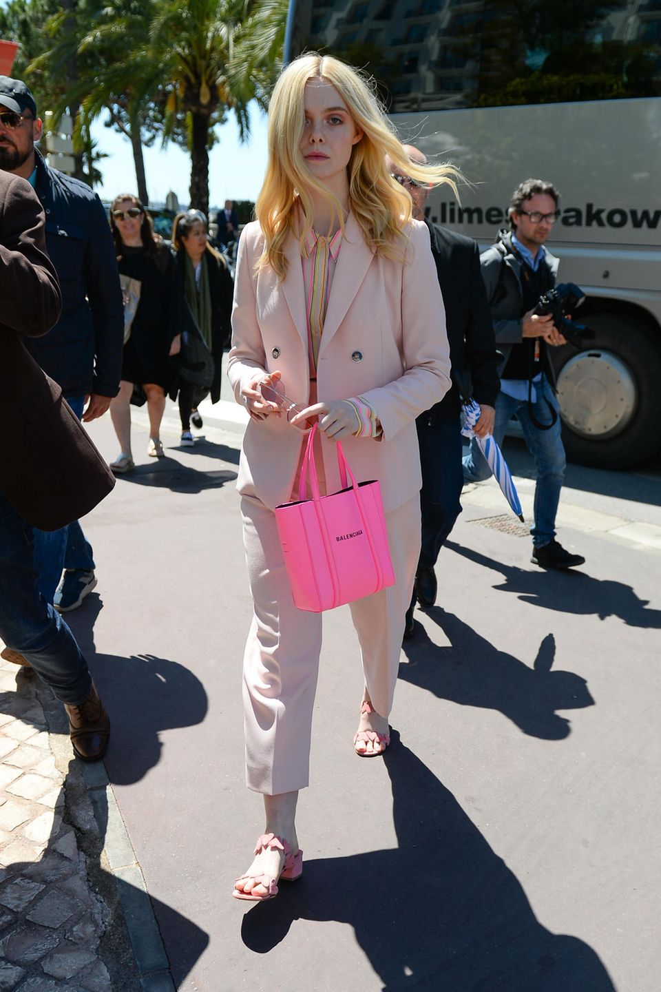 Bevor es zum Fotoshooting mit L’Oréal geht, spaziert Elle Fanning, diesjähriges Jurymitglied der Filmfestspiele, in einem rosafarbenen Hosenanzug und pinkfarbener Handtasche durch Cannes.
