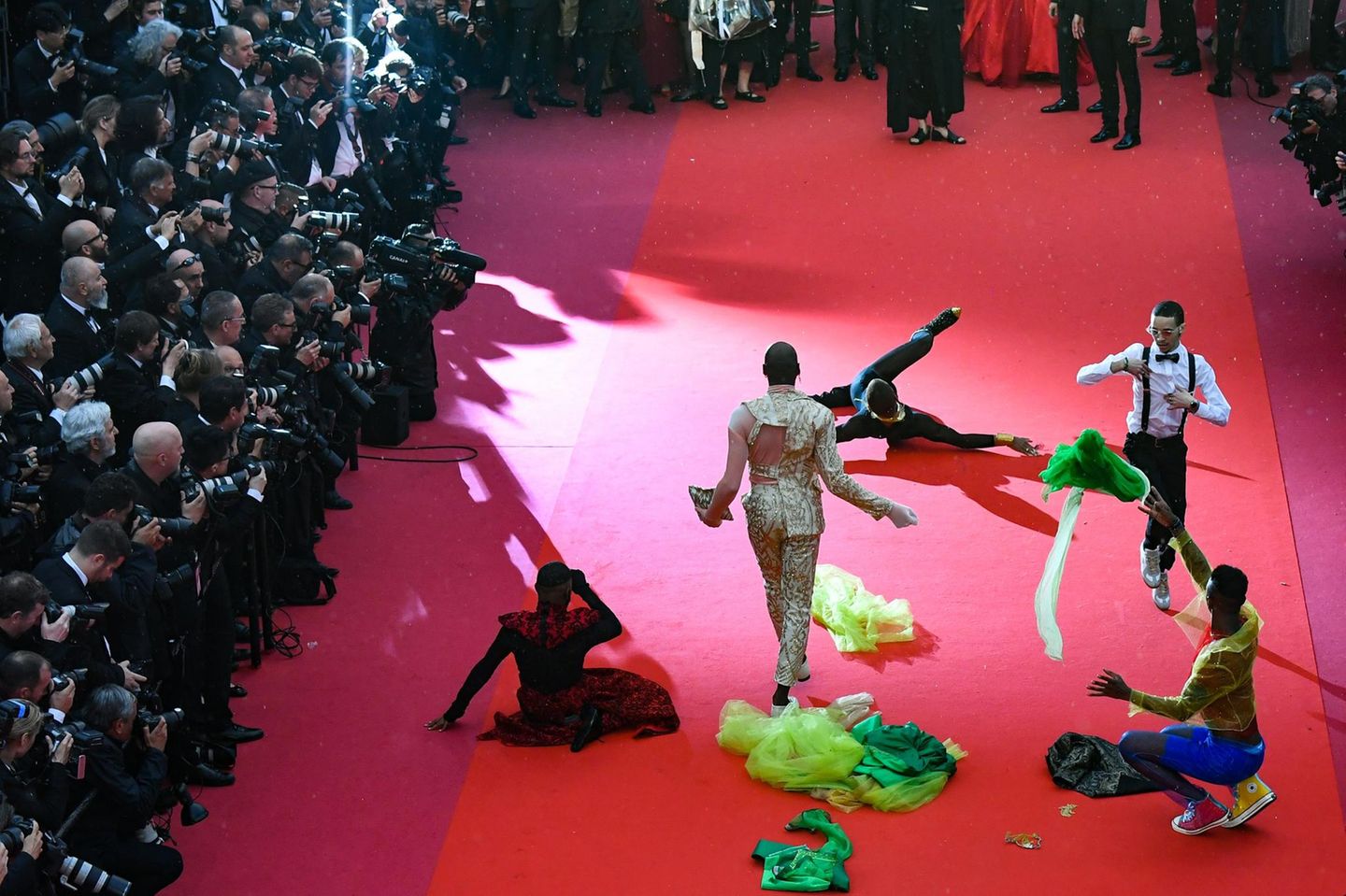 Diese Tänzer legen eine Performance auf dem roten Teppich hin. 