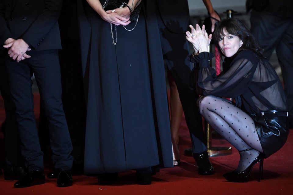 Bevor der Gang über den roten Teppich für Charlotte Gainsbourg losgehen kann, muss sich die Schauspielerin noch etwas gedulden und kniet sich kurzerhand hin. 