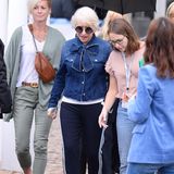 So geht Stilbruch: Helen Mirren trägt eine auffällige Jeansbluse mit Schleife und eine sportliche Hose mit weißen Streifen. Dazu kombiniert sie eine XL-Sonnenbrille und blaue Pumps. 