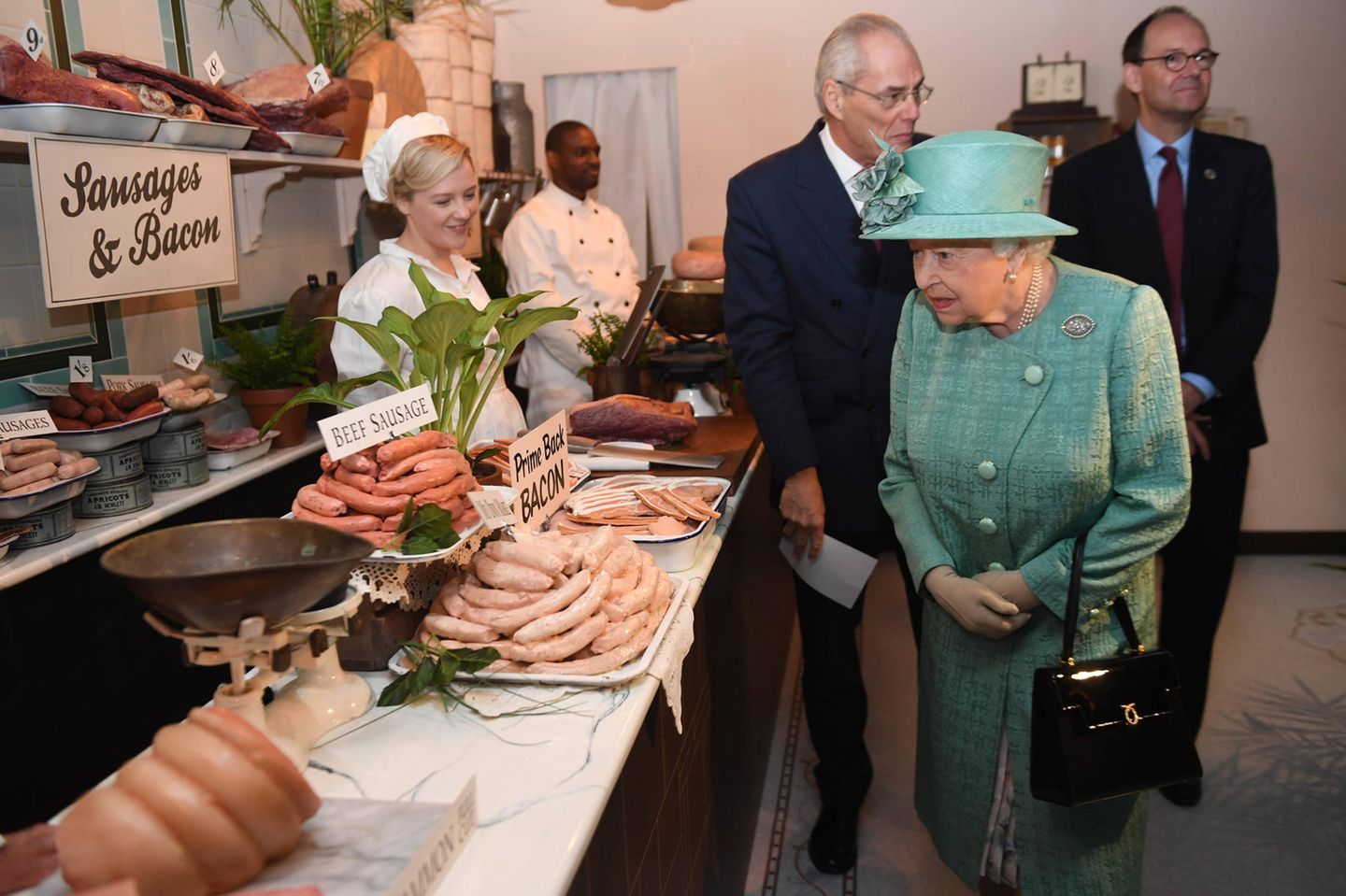 So sehen Supermarktketten heute nicht mehr aus. Queen Elizabeth begutachtet trotzdem interessiert die Lebensmittelauswahl, die Lord Sainsbury und seine Ehefrau für den hohen Besuch ausgewählt haben.