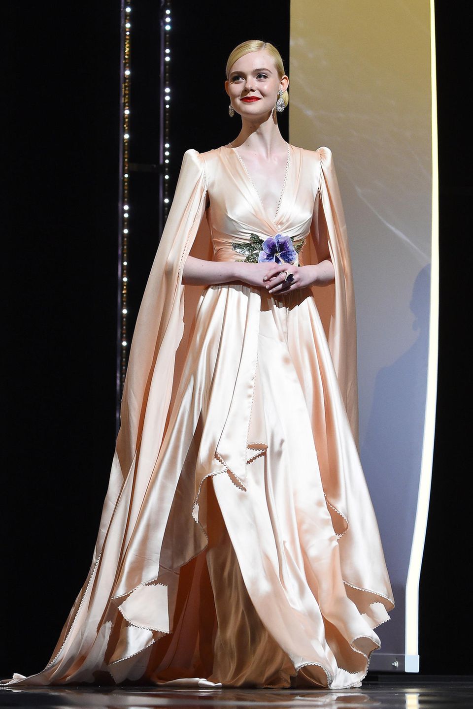 In zarten Pfirsich-Tönen bezauberte Elle bei der Eröffnungszeremonie der 72. Filmfestspiele in Cannes. Das Satin-Traumkleid mit Blüten-Applikation stammt aus dem Hause Gucci.