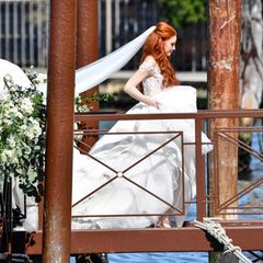 Da kommt die Braut! Wunderschön im floralen Hochzeitskleid mit langer Schleppe und langem Schleier schreitet Barbara Meier auf dem blumengeschmückten Steg Richtung Altar.