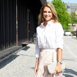 Madeleine trägt einen raffinierten Midirock mit Volants und einer eleganten Knopfleiste des Labels Aje für um die 510 Euro. Dazu kombiniert sie eine recht schlichte, weiße Bluse, beigefarbene Pumps von Manolo Blahnik und eine sommerliche Clutch von Botkier - diese besitzt Prinzessin Madeleine schon seit über zehn Jahren. 