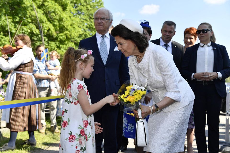 Ein kleines Mädchen überreicht Königin Silvia einen Strauß Blumen. Ein kleines Mädchen überreicht Königin Silvia einen Strauß Blumen.