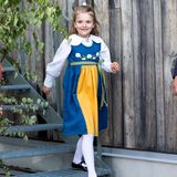 Für den Nationalfeiertag in Schweden hat sich Prinzessin Estelle schick gemacht: Sie trägt ein landestypisches Trachtenkleid in den schwedischen Nationalfarben, das mit weißen Blumen verziert ist. Eine weiße Strumpfhose und schwarze Lackschuhe runden den feierlichen Look der 7-Jährigen ab – doch etwas fehlt ...