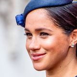Herzogin Meghan trägt ebenfalls einen tief sitzenden, seitlichen Dutt - jedoch weniger aufwendig gestylt. Hingucker ist ihr kleiner Fascinator-Hut, der stark an den Hut erinnert, den ihre Mutter Doria zu Meghans Hochzeit trug.