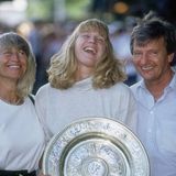 Mit ihren Eltern Heidi und Peter Graf freut sich Steffi 1991 über ihren Wimbledon-Sieg. Nur wenige Jahre später wird Peter Graf wegen Steuerhinterziehung verurteilt. Er verliert in dem Zuge seinen Posten als Steffis Manager. 1999 folgt die Scheidung von Heidi und Peter Graf.