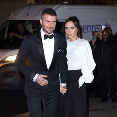 Das nennen wir mal einen perfekten Partnerlook: Während Göttergatte David Beckham einen klassischen Smoking trägt, wählt seine designende Ehefrau ein ebenfalls monochromes Outfit in Schwarz und Weiß, das lediglich durch knallpinke Pumps gebrochen wird.