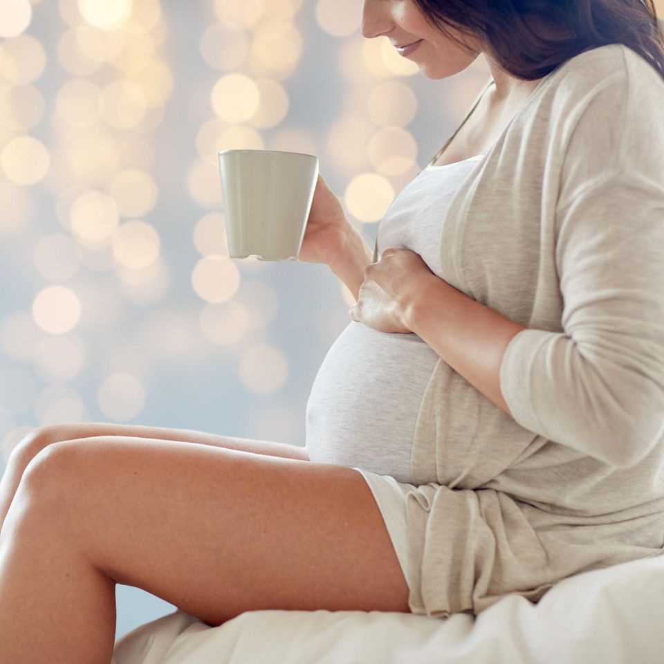 Frauenmanteltee, schwangere Frau mit Tee in der Hand