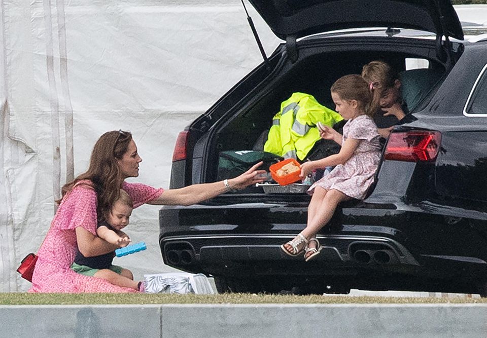 Herzogin Meghan + Herzogin Catherine: "Wir wollen auch Kekse!" Kate, mit Louis auf dem Schloß, lässt sich von Charlotte einePlastikdose reichen. Der süße Genuss lockt auch George aus dem Kofferraum. Herzogin Catherine, Prinz Louis, Prinz George und Prinzessin Charlotte