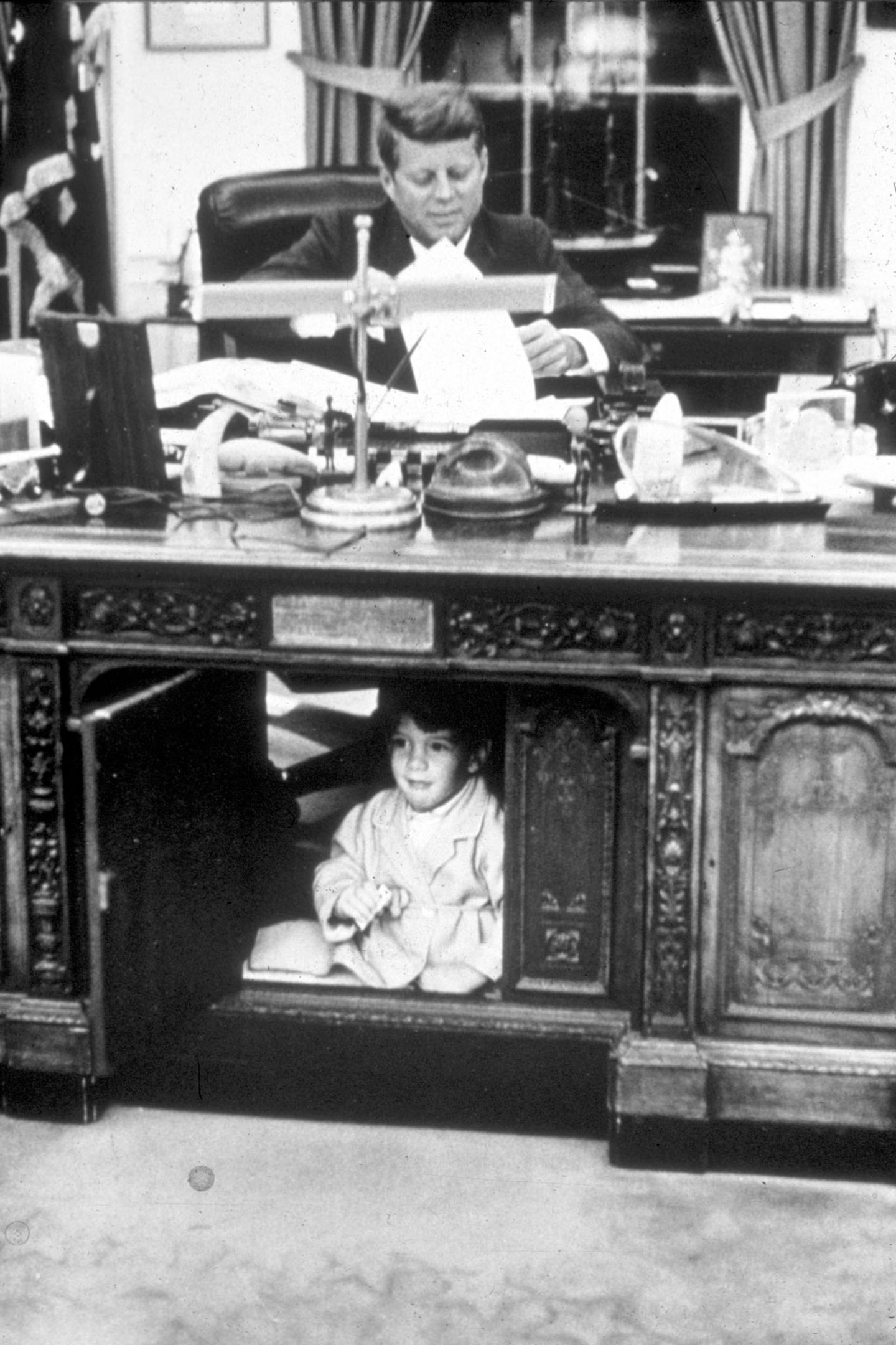 John-John hat sich im Oval Office unter dem Schreibtisch seines Vaters versteckt.