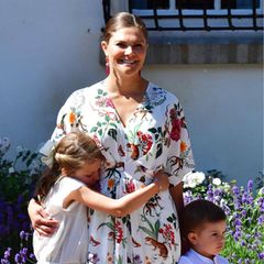 Prinzessin Estelle scheint noch etwas müde zu sein. Sie kuschelt sich an ihre Mutter und schließt kurz die Augen. Ihr Bruder, Prinz Oscar, hört währenddessen seinem Opa zu.