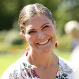Farblich auf die Blumen auf ihrem Kleid abgestimmt, trägt Prinzessin Victoria bunte, hängende Ohrringe.