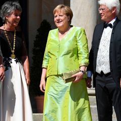 In einem glänzend-grünen Zweiteiler strahlt Angela Merkel mit der Sonne in Bayreuth um die Wette. Seit Jahren gehört sie zu den wichtigsten Gästen der Bayreuther Festpiele, die jährlich zu Ehren der letzten zehn Opern Richard Wagners auf dem Grünen Hügel stattfinden. Ob sie uns mit diesem Look klarmachen möchte, dass bei ihr nach den Zitteranfällen alles im Grünen ist? 