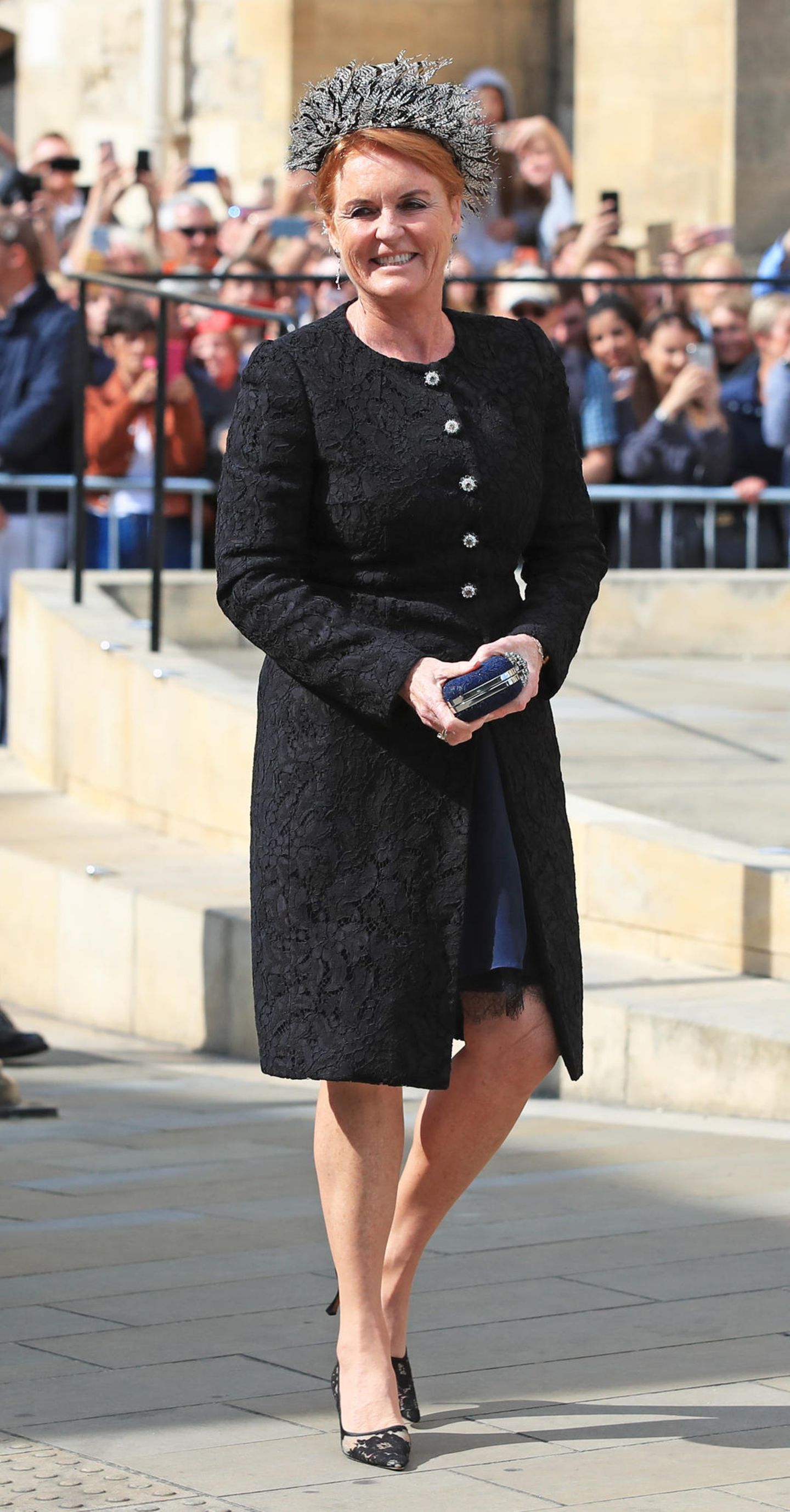 Eine sichtlich gut gelaunte Sarah Ferguson vor der York Minster. Die 59-Jährige kommt in einem schwarzen Look – eigentlich ein No-Go bei einer Hochzeit. Unter dem schwarzen Brokat-Mantel zeigt sich allerdings, dass sie sich für ein blaues Kleid entschieden hat.