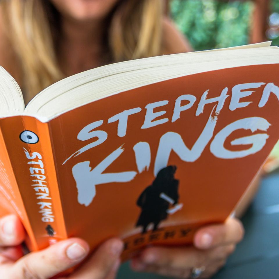 Stephen-King-Buch, Frau liest in dem Buch "Misery" von Stephen King