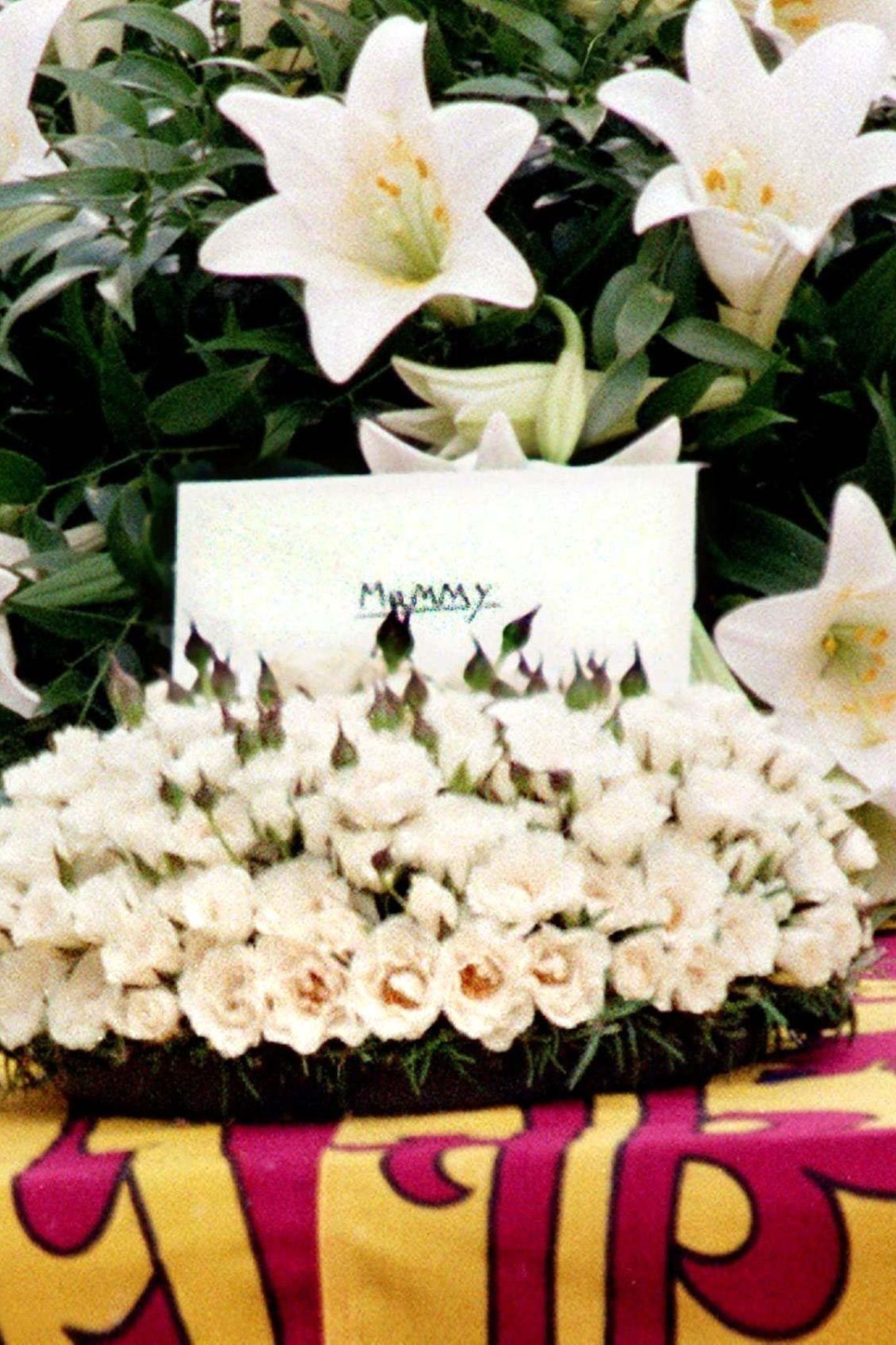 In einem Blumenbouquet auf dem Sarg steckt ein Brief, den Harry und William ihrer Mutter mit auf ihre letzte Reise geben. "Mummy" steht in Großbuchstaben auf dem Umschlag. Ein Detail, dass Beobachtern besonders zu Herzen geht. 