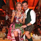 Giulia Siegel und ihr Partner Ludwig Heer tanzen ausgelassen auf den Bierzeltbänken. 