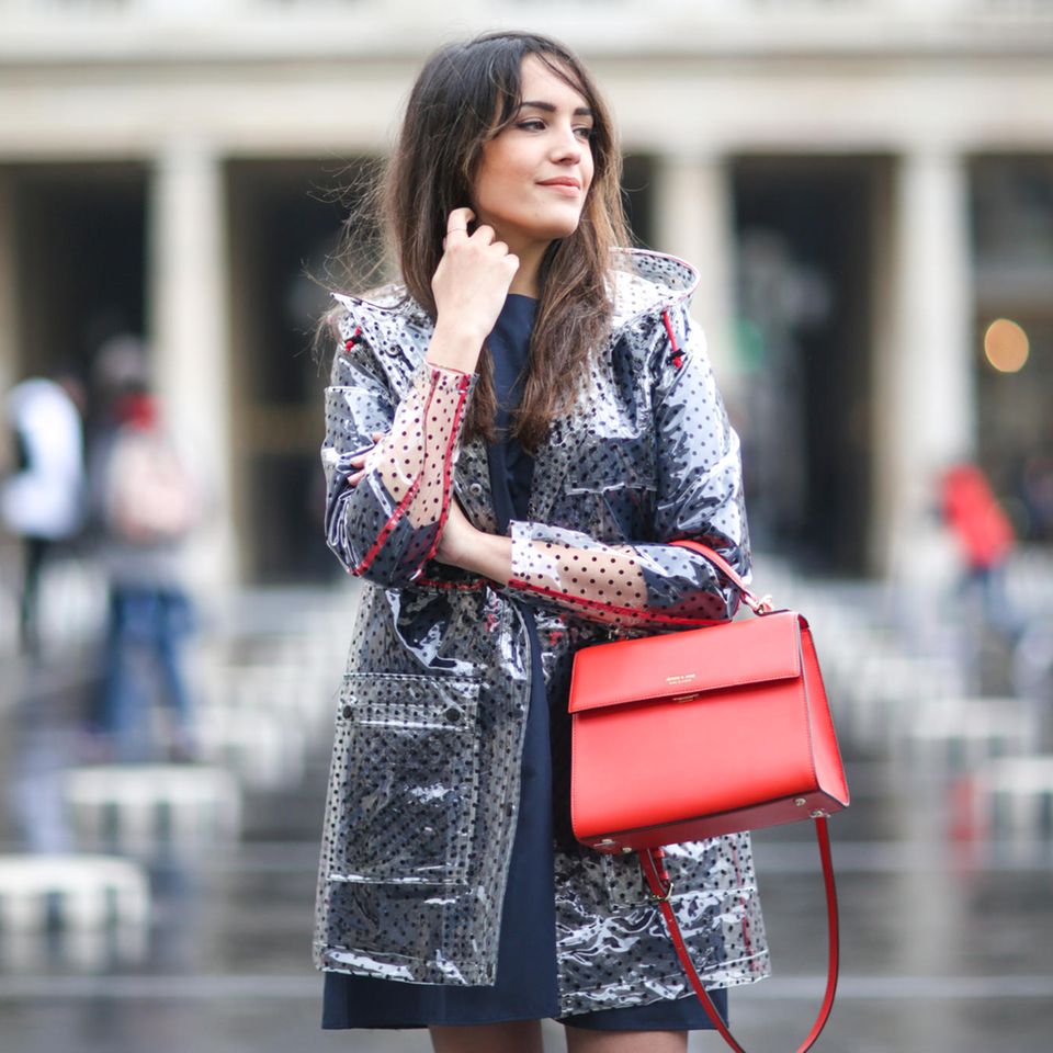 Regenkleidung, Frau auf der Straße mit Regenjacke und Handtasche