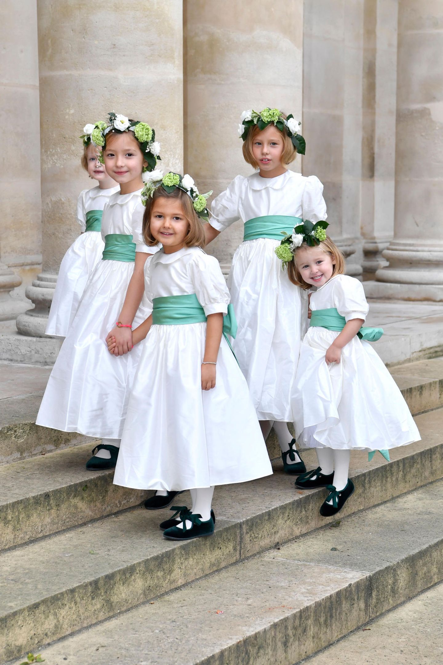 Die niedlichen Blumenmädchen tragen Kränze im Haar und erinnern mit ihren Kleidchen und dem mintgrünen Schleifen ein wenig an die Blumenkinder der Hochzeit von Prinzessin Eugenie und Jack Brooksbank.